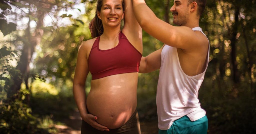 Zwangere vrouw doet personal training oefening onder begeleiding van professionele trainer