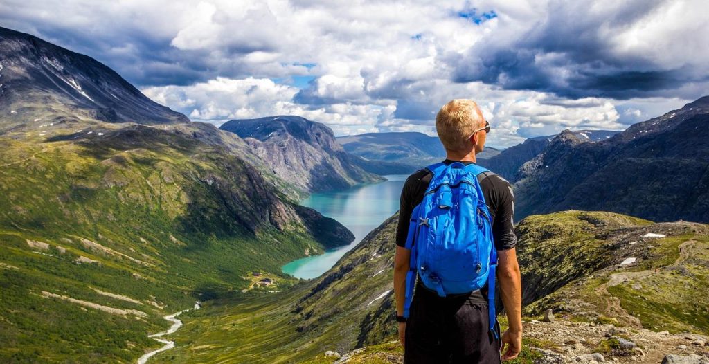 Panoramisch uitzicht op een Noorse fjord met steile bergen en helderblauwe water, ideaal voor een vakantie in Noorwegen