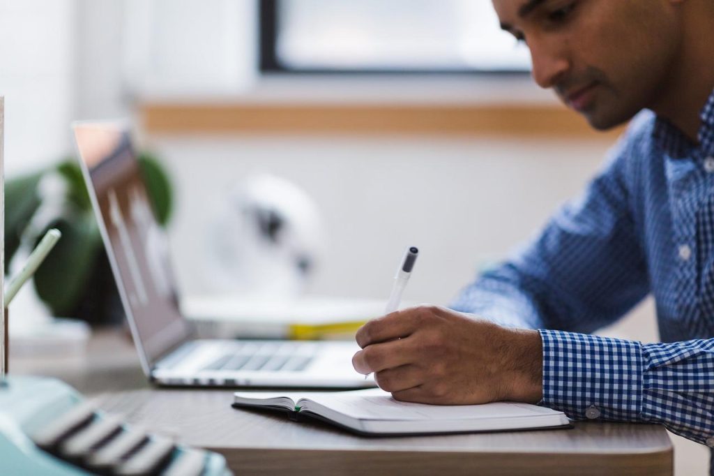 Ouder ondersteunt kind bij huiswerkbegeleiding met schema en organisatie