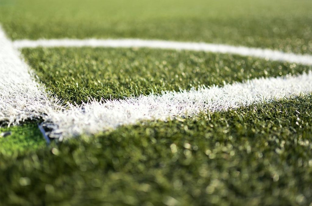 Voetballer oefent dribbelen en technische voetbalvaardigheden op het trainingsveld